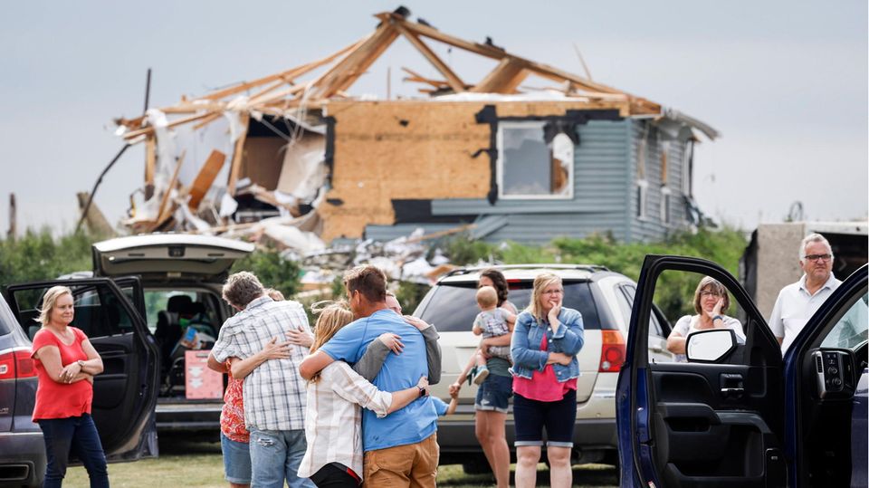 Menschen trösten sich, nachdem ein Tornado über die Provinz Alberta in Kanada hinweggefegt ist Menschen trösten sich, nachdem ein Tornado über die Provinz Alberta in Kanada hinweggefegt ist