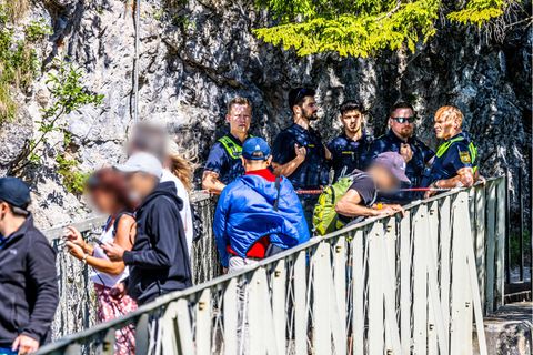 An der Marienbrücke beim Schloss Neuschwanstein wachen vier Polizisten über die Touristen