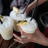 Drei Becher mit Pina Colada stehen auf einem Tisch