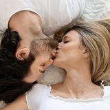 Paar küsst sich im Bett