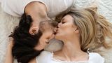 Paar küsst sich im Bett