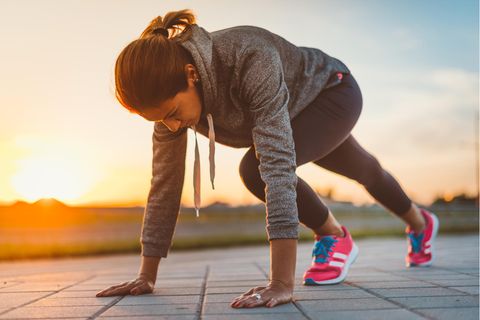 Eine Frau wärmt sich fürs Joggen auf.