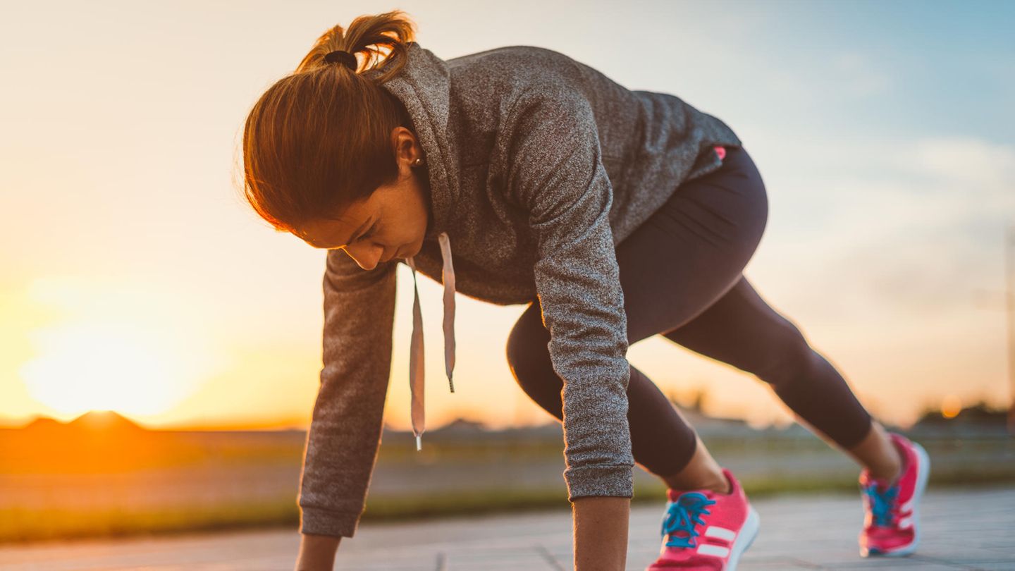 Eine Frau wärmt sich fürs Joggen auf.