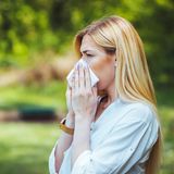 Frau putzt sich die Nase