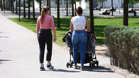 Zwei junge Frauen gehen mit einem Kinderwagen spazieren (Symbolbild)