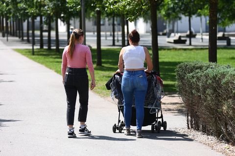 Zwei junge Frauen gehen mit einem Kinderwagen spazieren (Symbolbild)