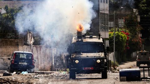 Ein israelisches Panzerfahrzeug feuert in der Stadt Dschenin im besetzten Westjordanland Tränengas ab