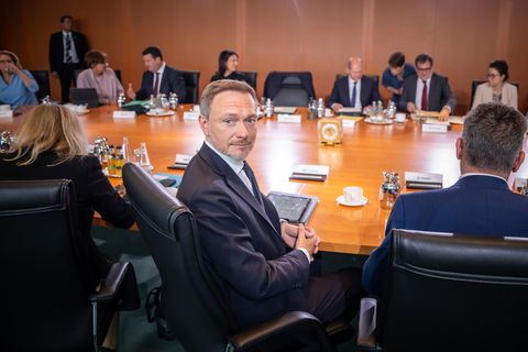 Das Bundeskabinett sitz an einem runden Tisch, während Christian Lindner sich vor den Beratungen zum Bundeshaushalt umdreht