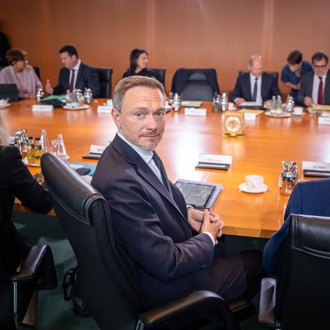 Das Bundeskabinett sitz an einem runden Tisch, während Christian Lindner sich vor den Beratungen zum Bundeshaushalt umdreht