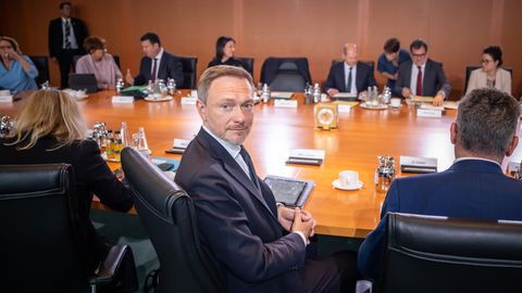 Das Bundeskabinett sitz an einem runden Tisch, während Christian Lindner sich vor den Beratungen zum Bundeshaushalt umdreht