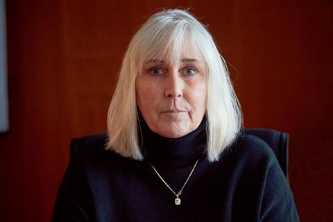 Sterbehilfe: Eine Frau, Bettina Steckmann, sitzt mit gefalteten Händen an einem Tisch und schaut in die Kamera.