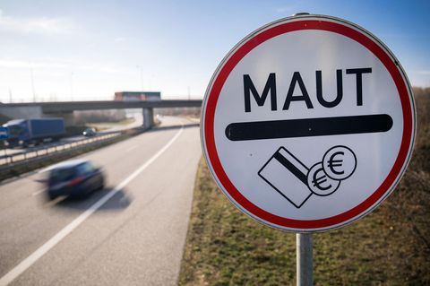 An einer Autobahn steht ein Hinweisschild, dass hier Maut anfällt