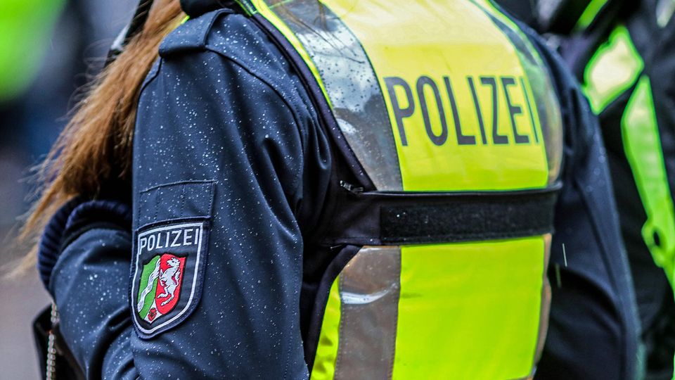 Eine Polizistin in Nahaufnahme mit Schutzweste und Schriftzug Polizei