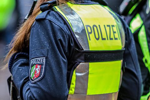 Eine Polizistin in Nahaufnahme mit Schutzweste und Schriftzug Polizei