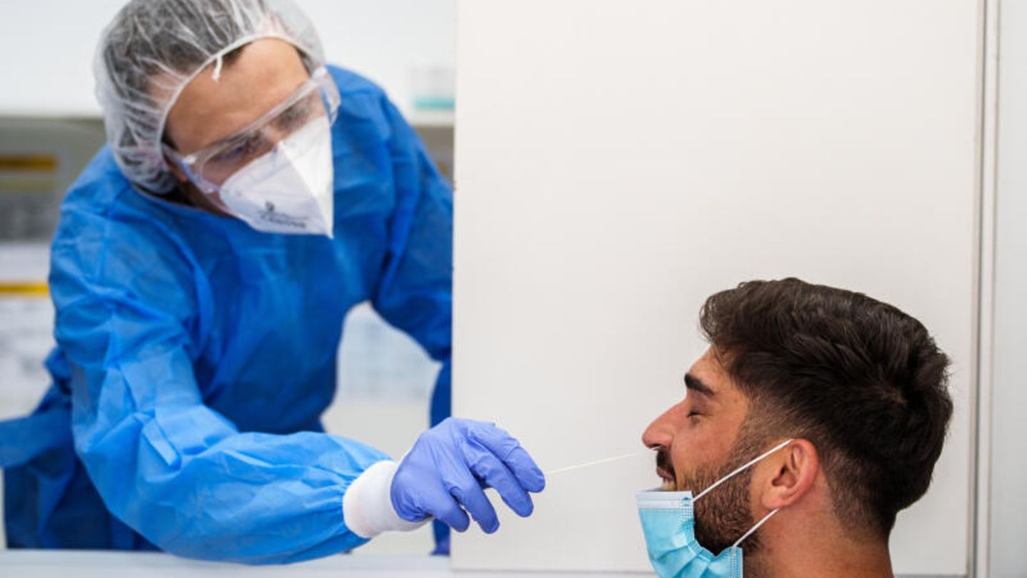 Ein Mitarbeiter einer Teststation führt einen Corona-Test durch