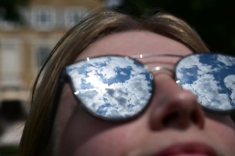 Geo-Engineering: Eine Frau schaut mit Sonnenbrille in den Himmel