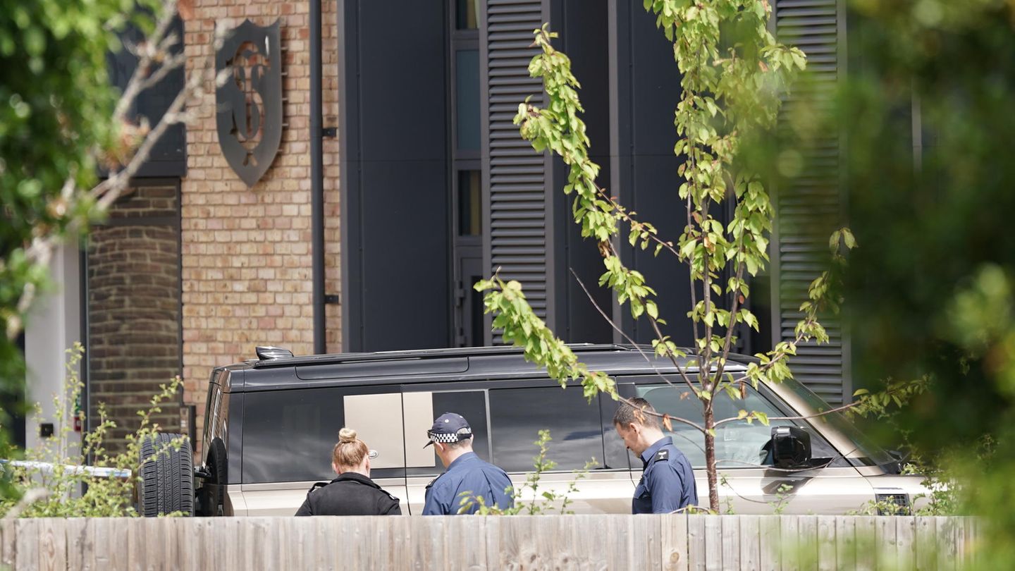 Auf einem Schulhof in London betrachten Polizisten einen Landrover
