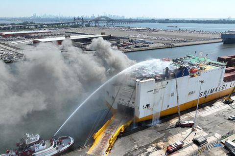 Die Luftaufnahme zeigt die Löscharbeiten an einem brennenden Frachtschiff in Newark