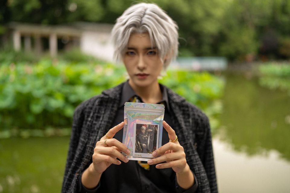 Fang Huaitang zeigt einen Sticker mit ihrem Videogamecharakter darauf Fang Huaitang zeigt einen Sticker mit ihrem Videogamecharakter darauf