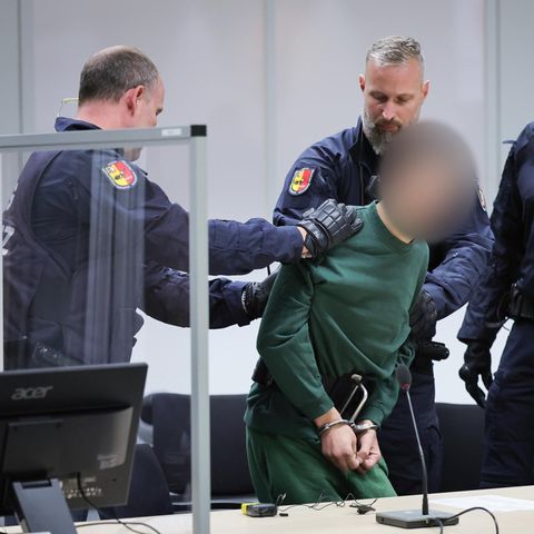 Prozessauftakt Brokstedt: Ibrahim A. wird in Handschellen von Polizisten in den Gerichtssaal geführt