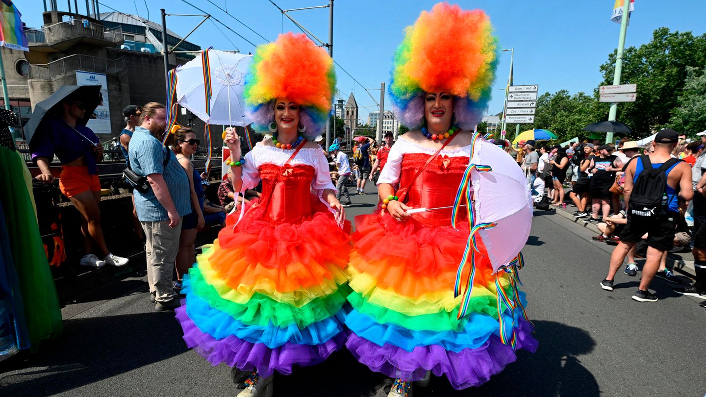 Zwei Teilnehmende in Regenbogenkleidern