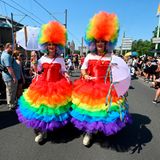 Zwei Teilnehmende in Regenbogenkleidern