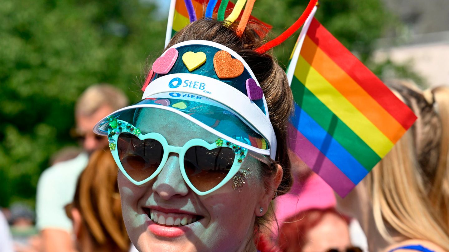 Eine Frau mit buntem Kopfschmuck in Regenbogenfarben