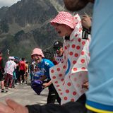 Tour de France. Ein Radfahrer fährt einen Berg hinauf. Menschen am Straßenrand feuern ihn an.