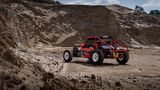 DerTamiya Wild One steht als reales Elektroauto in einem bergigen Gelände