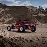 DerTamiya Wild One steht als reales Elektroauto in einem bergigen Gelände