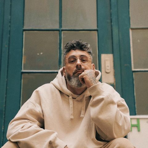 Sido in beigem Hoodie auf einer Treppe sitzend