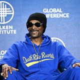 Im Cannabis-Geschäft: Rapper Snoop Dogg sitzt mit einer Mütze und Sonnenbrille lächelnd auf einem Sofa