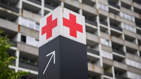 Ein Schild mit einem roten Kreuz weist den Weg zur Notaufnahme eines Krankenhauses