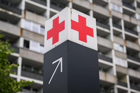 Ein Schild mit einem roten Kreuz weist den Weg zur Notaufnahme eines Krankenhauses