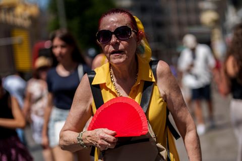 Ein weiterer Hitzesommer in Spanien: Eine Frau in Madrid fächelt sich Luft zu