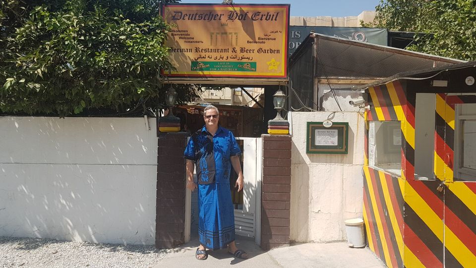 Ein Mann in einem Gewand, der Wirt, steht vor dem Eingang des "Deutschen Hofs" in Erbil