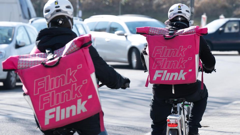 Zwei Radfahrer mit Flink-Taschen auf dem Rücken