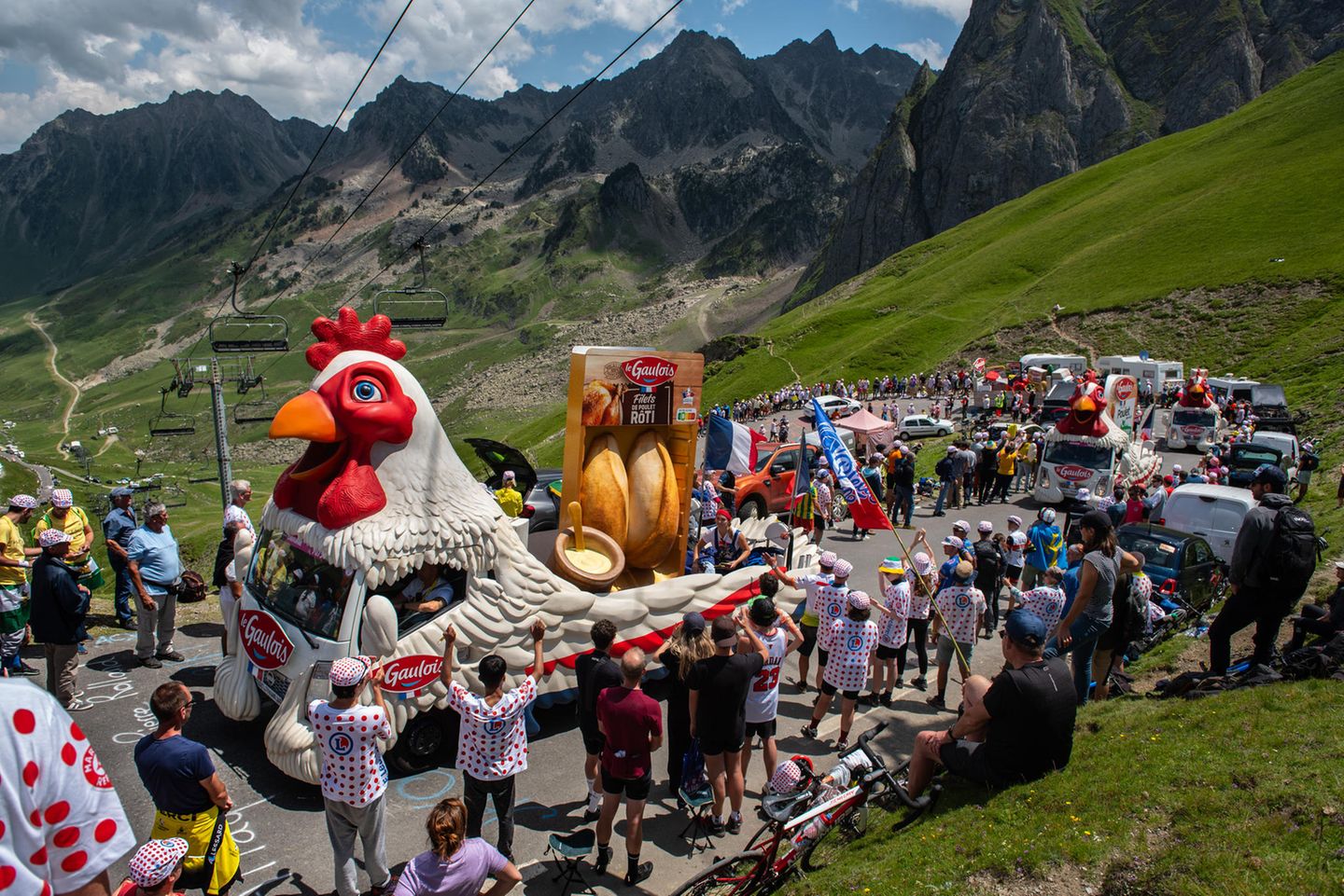 Auch aufwändig geschmückte Festwagen fahren auf der Strecke der Tour de France