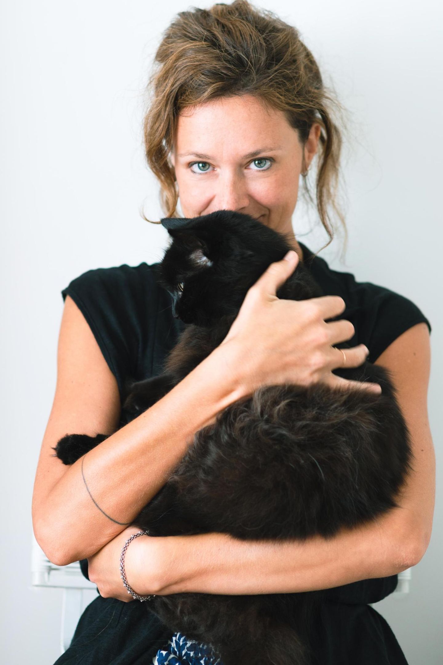 Die Fotografin Diana Bagnoli hält ihre schwarze Katze Kina im Arm