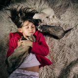 Ein Mädchehn kuschelt mit drei Frettchen