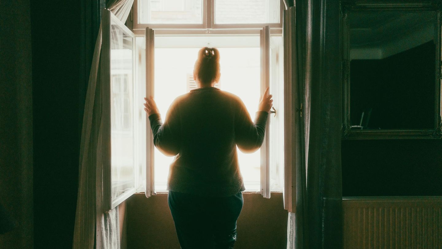 Thema Häusliche Gewalt: Einsame Frau steht am Fenster