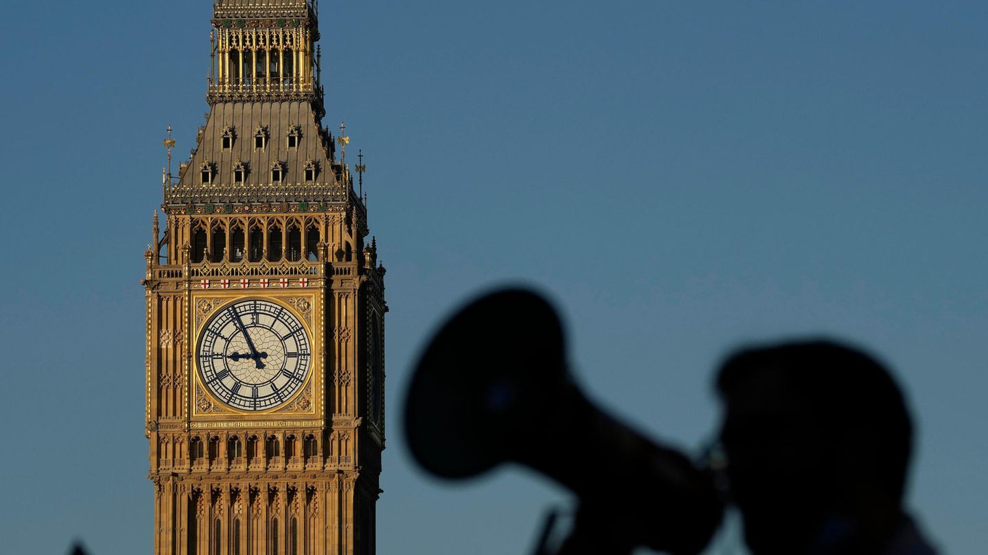 Ein Demonstrant mit einem Megaphon ruft vor dem Big Ben Slogans
