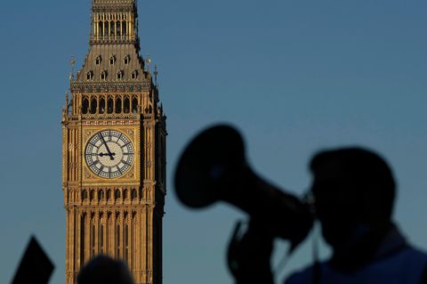 Ein Demonstrant mit einem Megaphon ruft vor dem Big Ben Slogans