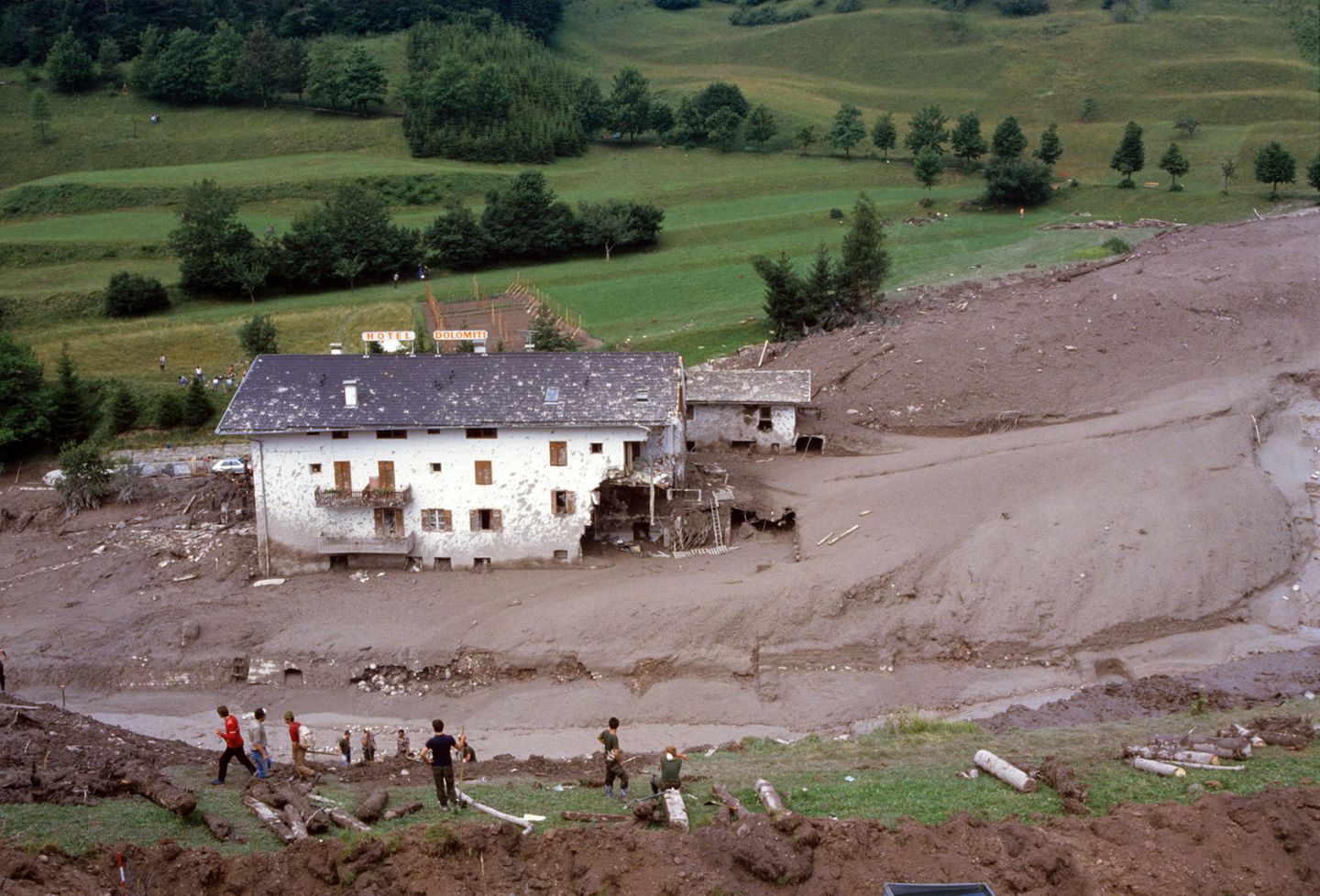 Helfer blicken auf das teilweise zerstörte Hotel "Dolomiti" in Stava di Tesero