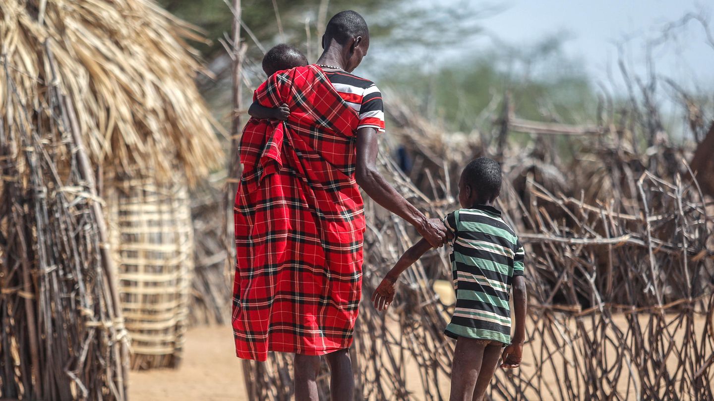 Hunger in Kenia: Ein Vater hilft seinem unterernährten Sohn beim Gehen in der Nähe ihrer Hütte