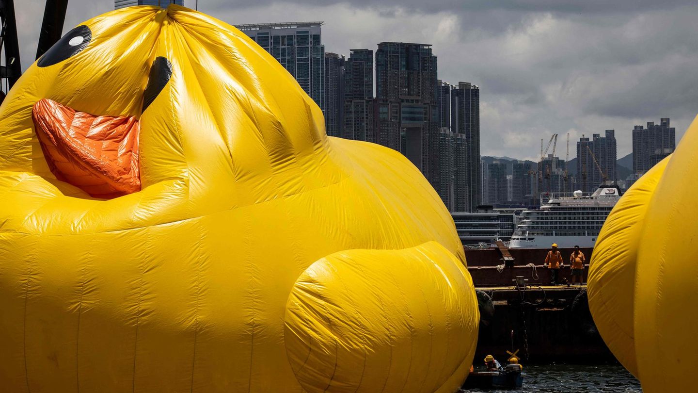 Arbeiter beaufsichtigen eine der beiden großen aufblasbaren Enten mit dem Namen "Double Ducks" des niederländischen Künstlers Florentijn Hofman im Victoria Harbour. Zum Schutz vor der Sommerhitze waren die Installationen zwischenzeitlich entleert worden. In Teilen Chinas herrscht bereits seit Wochen ungewöhnliche Hitze. Vor allem der Norden des Landes war von den hohen Temperaturen stärker und früher als üblich betroffen.