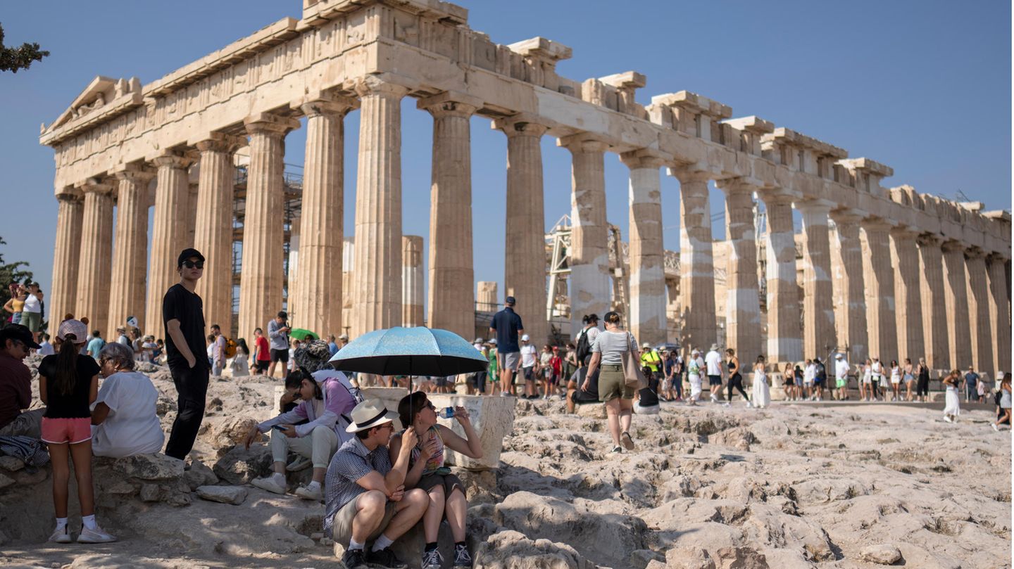 Touristen vor dem Parthenon-Tempel auf dem Akropolis-Hügel suchen Schutz vor der Sonne. Am Wochenende werden in Griechenland Höchsttemperaturen von über 40 Grad erwartet.