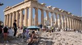 Touristen vor dem Parthenon-Tempel auf dem Akropolis-Hügel suchen Schutz vor der Sonne. Am Wochenende werden in Griechenland Höchsttemperaturen von über 40 Grad erwartet.