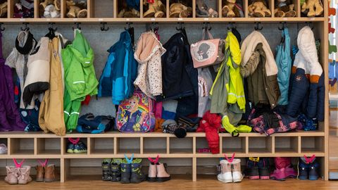 Die Garderobe einer Kita, vielen Jacken und Schuhen von Kindern