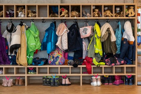 Die Garderobe einer Kita, vielen Jacken und Schuhen von Kindern